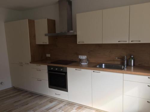a kitchen with white cabinets and a sink at Apartment Lärchenstube in Mieders