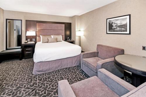 a hotel room with a bed and a couch at Best Western Plus Banff International Lodge in Banff