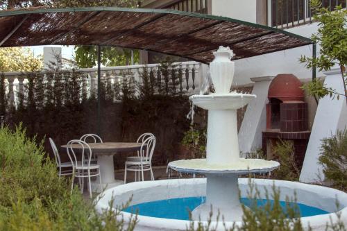 una fontana in un cortile con tavolo e sedie di La Berruca Casa Rural Malpartida de Cáceres a Malpartida de Cáceres