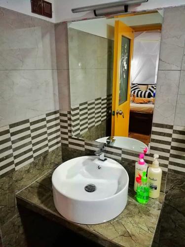 a bathroom with a white sink and a mirror at Home Away Ella in Ella