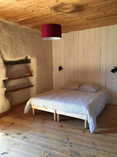 - une chambre avec un lit dans une pièce dotée d'un plafond en bois dans l'établissement Gîte Les Clots Clément, à Les Clots