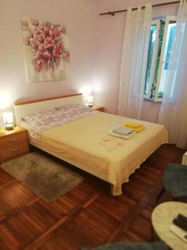 a small bedroom with a bed and a window at Rooms Tusculum in Opatija