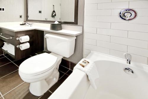 a bathroom with a toilet and a sink and a tub at Best Western Plus Banff International Lodge in Banff
