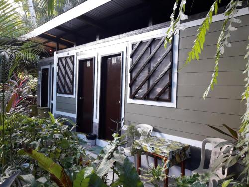 a porch of a house with a door and a table at Villa Evergreen Restaurant and Rooms in San Vicente