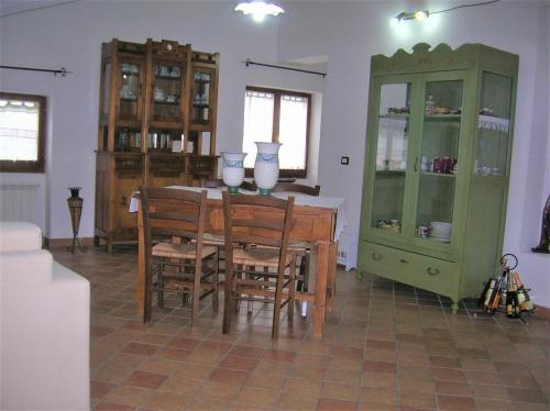 a dining room with a table and a green cabinet at MANSARDA VITI - Sguardo su Frontone - in Frontone