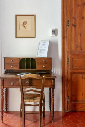 a wooden desk with a chair next to a door at Entre Midi - Maison d'Hôtes - B&B in Capestang