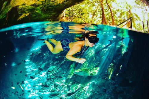 a woman swimming in a swimming pool in the water at Maria Del Mar Tulum - Adults Only in Tulum