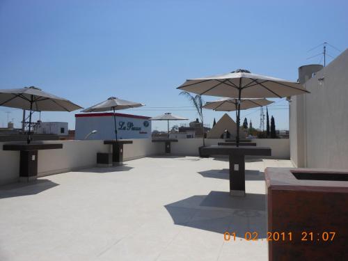 a group of tables with umbrellas on a roof at Hotel Gya Boutique in Aguascalientes