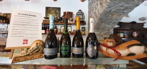 un grupo de botellas de vino en una mesa de cristal en Taverna del Dolmen, en Millesimo