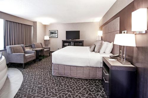 a hotel room with a bed and a television at Best Western Plus Banff International Lodge in Banff