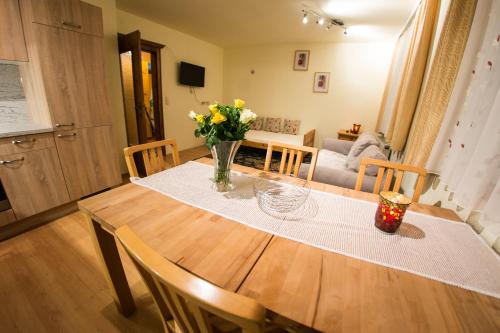 a dining room table with a vase of flowers on it at Europa Pension Tirol in Fliess