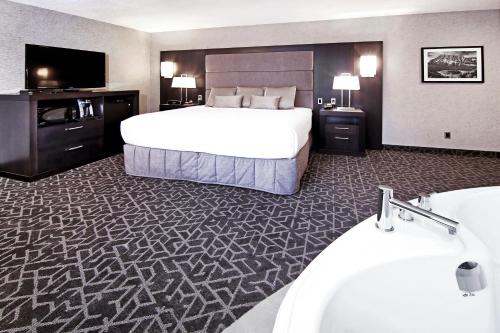 a hotel room with a large bed and a large mirror at Best Western Plus Siding 29 Lodge in Banff
