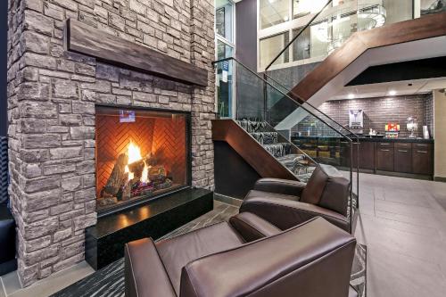 a lobby with a fireplace and leather chairs at Best Western Plus Siding 29 Lodge in Banff