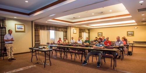 a group of people sitting at tables in a room at Round Hill Inn in Orange