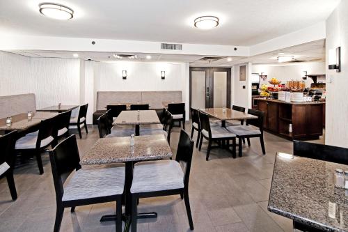 a restaurant with tables and chairs and a kitchen at Best Western Plus Banff International Lodge in Banff