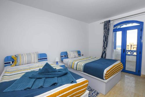 two beds in a room with a window at Luxury Villa with pool in Hurghada in Hurghada