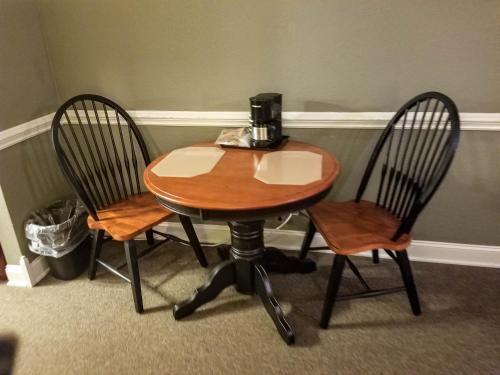 a wooden table with two chairs and a coffee maker on it at Lily Pad Suites in Andrews