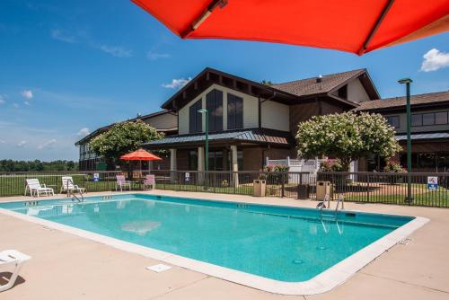 a swimming pool in front of a house with an umbrella at Round Hill Inn in Orange