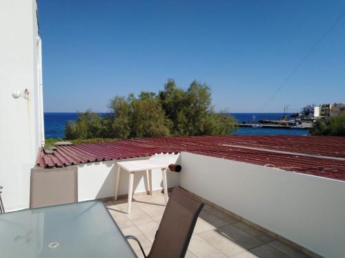 a balcony with a table and a view of the ocean at Odyssey Apartment in Palaiochóra