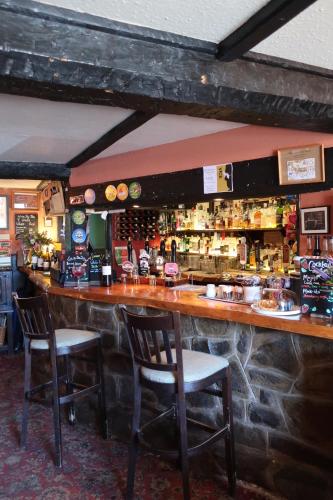 un bar con due sedie sedute al bancone di The Lamb Inn a Crediton