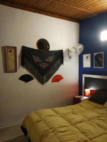 a bedroom with a bed with a blanket on the wall at Playa, bosque y lago in Montevideo