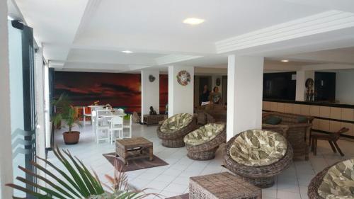 a living room with couches and chairs and a table at Apartamentos Hotel Marinas in Tamandaré