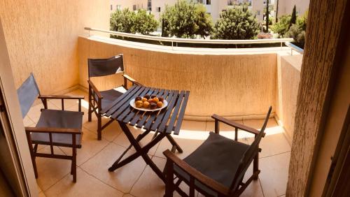 een tafel en stoelen en een fruitschaal op een balkon bij Private apartment at Aristo Universe III with pool in Paphos City