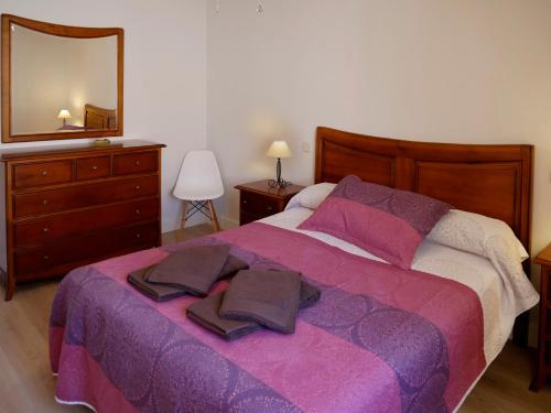 a bedroom with a large bed with a purple blanket at Casa Rural el Reencuentro "Grupo Mirando a Gredos" in Cadalso de los Vidrios
