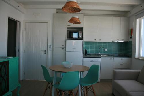 a kitchen with a table and chairs in a room at Recantus Comporta in Comporta