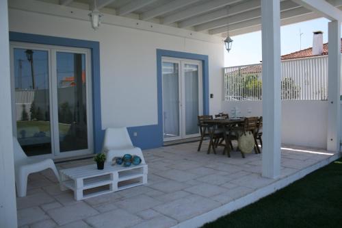 a white house with a patio with a table at Recantus Comporta in Comporta