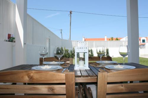 a wooden table with wine glasses on top of it at Recantus Comporta in Comporta