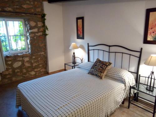 1 dormitorio con 1 cama y 2 mesas con lámparas en Cortijo Ferradores en Humilladero