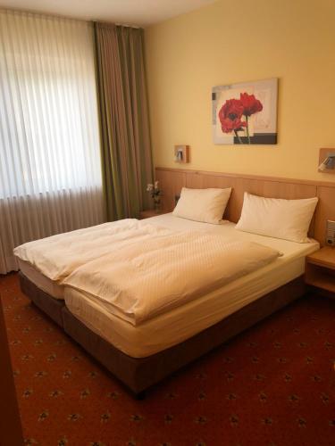 ein Schlafzimmer mit einem großen Bett in einem Zimmer in der Unterkunft Landhotel Heiner Meyer in Wahrenholz