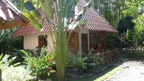 a small house with a fence in a garden at Naturalmente Boutique Bungalows y Cocina Mediterránea in Las Lajas