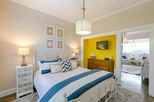 a bedroom with a bed and a yellow wall at Quarterdeck in Oamaru