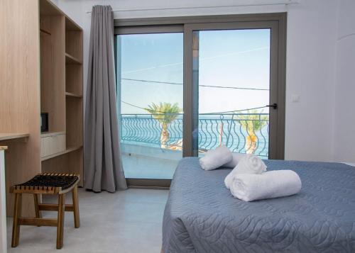 a bedroom with a bed with a view of the ocean at Ellie Apartments Stalida in Stalís