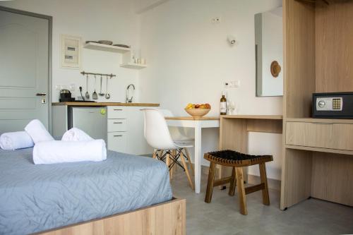 a bedroom with a bed and a kitchen with a table at Ellie Apartments Stalida in Stalida
