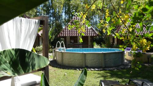 a hot tub in a yard with a tree at Naturalmente Boutique Bungalows y Cocina Mediterránea in Las Lajas