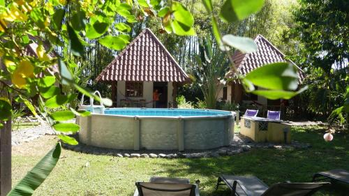 a hot tub in a yard with a house at Naturalmente Boutique Bungalows y Cocina Mediterránea in Las Lajas