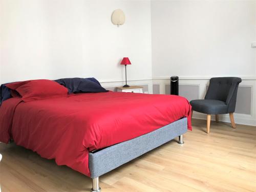 una camera con letto rosso e sedia nera di Le secret de Léa a Rouen