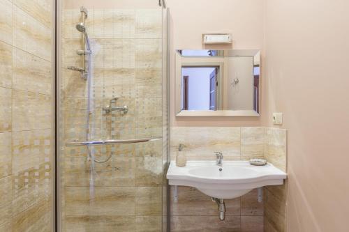 a bathroom with a sink and a shower at Nika Apart Hotel in Riga