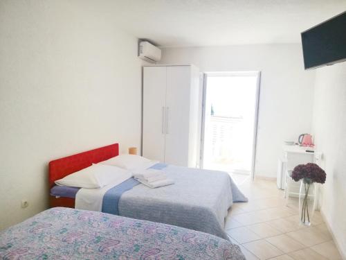 a bedroom with two beds and a window at Rooms Villa Gala in Mlini