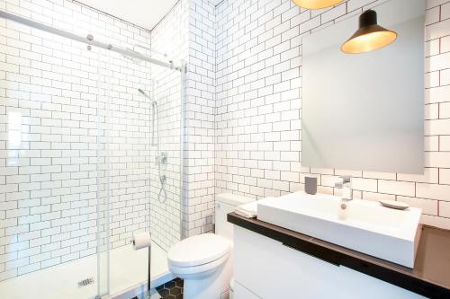 a white bathroom with a sink and a toilet at Les Lofts St-Vallier - Par Les Lofts Vieux Québec in Quebec City