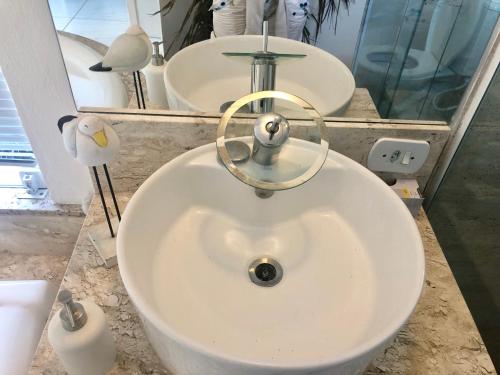 a white sink in a bathroom with two mirrors at Villa Bella Vista in Cabo Frio