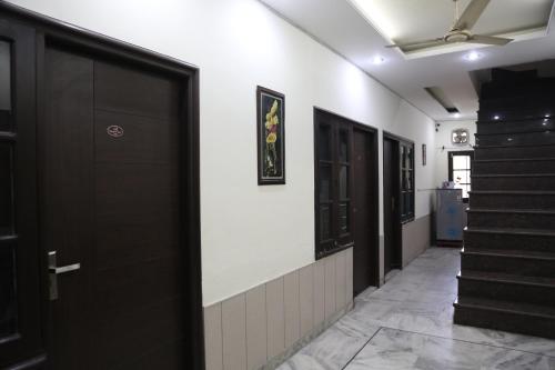 a hallway with black doors and stairs in a building at Time Square Guest House in Jalandhar