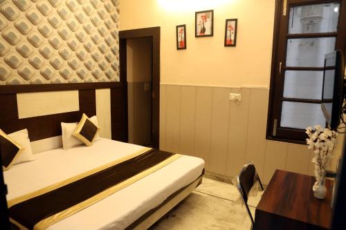 a bedroom with a bed and a table and a window at Time Square Guest House in Jalandhar