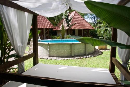 a view of the pool from the porch of a villa at Naturalmente Boutique Bungalows y Cocina Mediterránea in Las Lajas