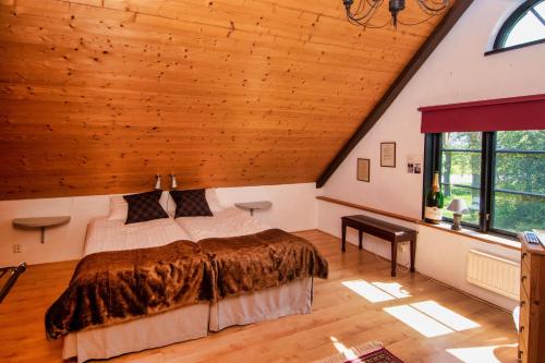 sypialnia z łóżkiem i drewnianym sufitem w obiekcie Gammalsbygårdens Gästgiveri w mieście Degerhamn