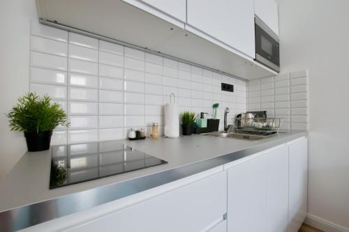 a white kitchen with a counter and a sink at Standard Apartment by Hi5 - Anker 1 in Budapest