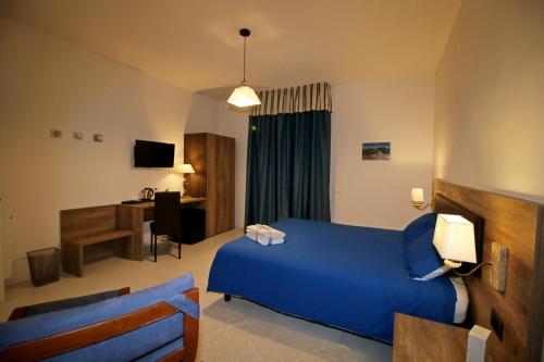 a hotel room with a blue bed and a desk at B & B LA MARMIFERA in Carrara